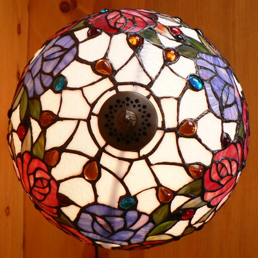 薔薇があでやかな大きなステンドグラス／宙に浮かぶ常夜灯がまるで