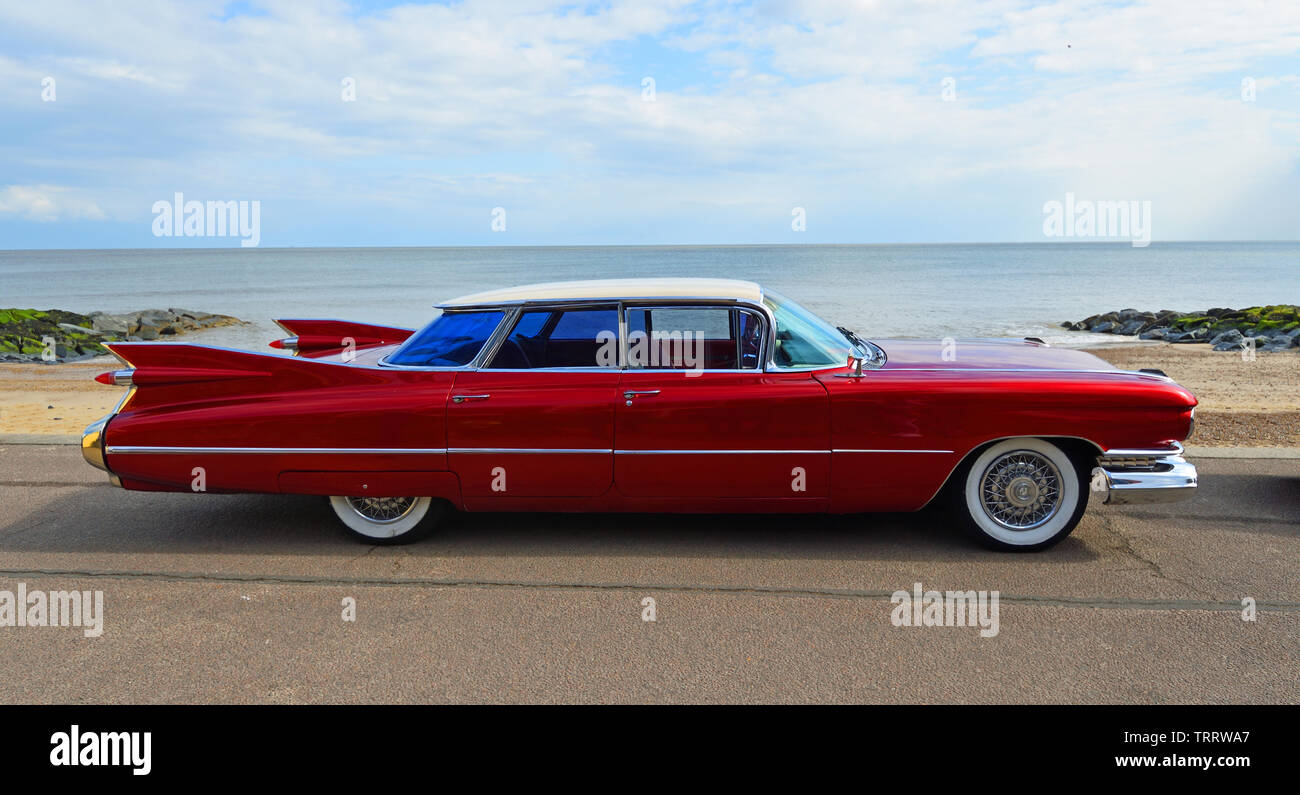 Classic Red 1950's 4 door Cadillac motor car parked on seafront
